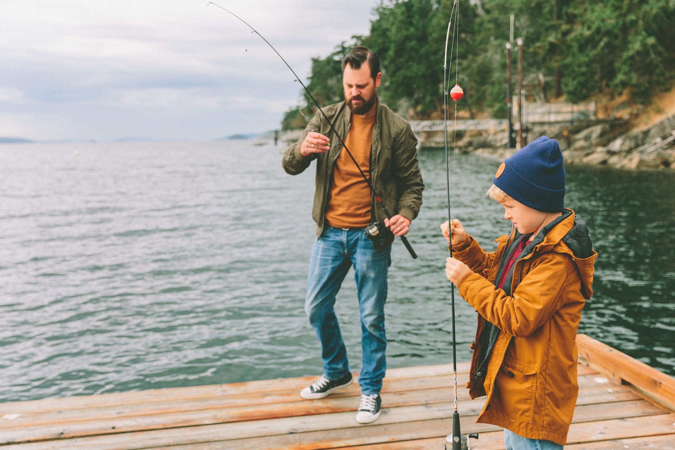 father and son adjusting their fishing poles as they are about to cast them off of the dock Cybersecurity Awareness Month