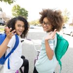 Two students riding their bikes to school.