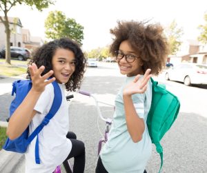 Two students riding their bikes to school.