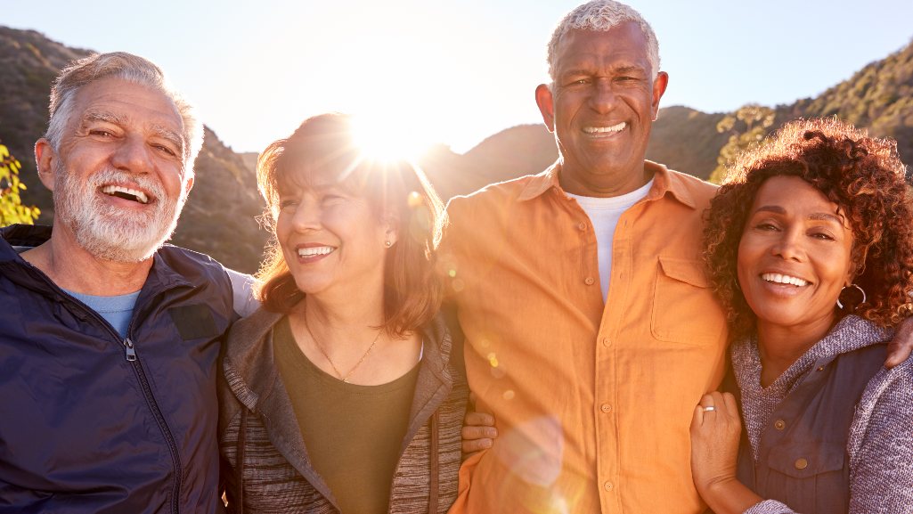 Two couples standing in front of the camera, arm in arm.