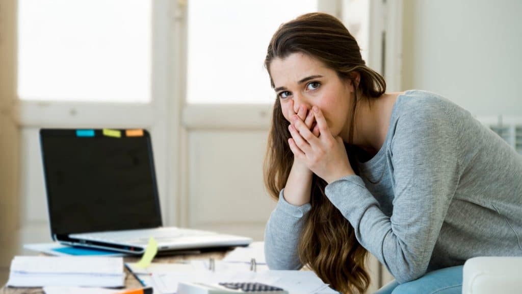 Worried woman suffering stress while paying bills and loan payments.