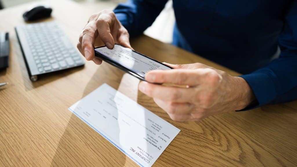 Business owner using Remote Deposit Capture to deposit checks into his People Driven Credit Union Business Checking Account.