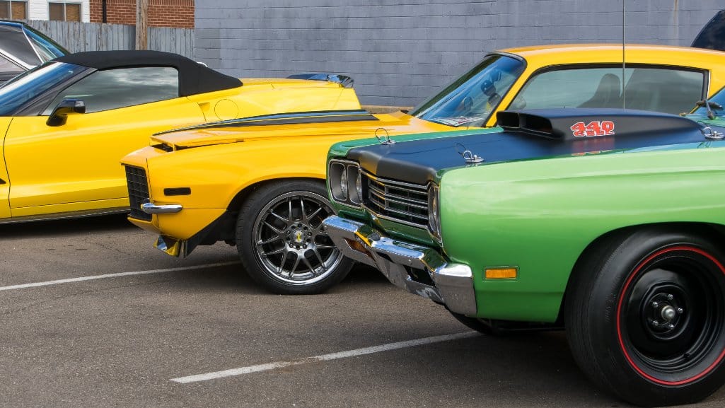 Classic cars lined up in a parking lot at the Woodward Dream Cruise.