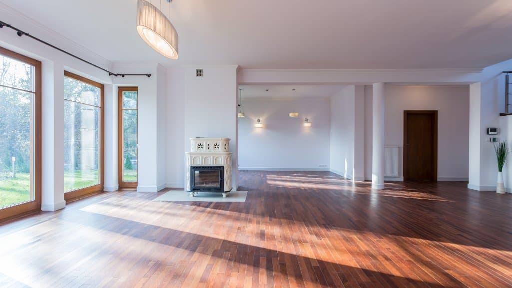 Spacious empty living room with large windows and hardwood floors, often seen in fake rental postings.