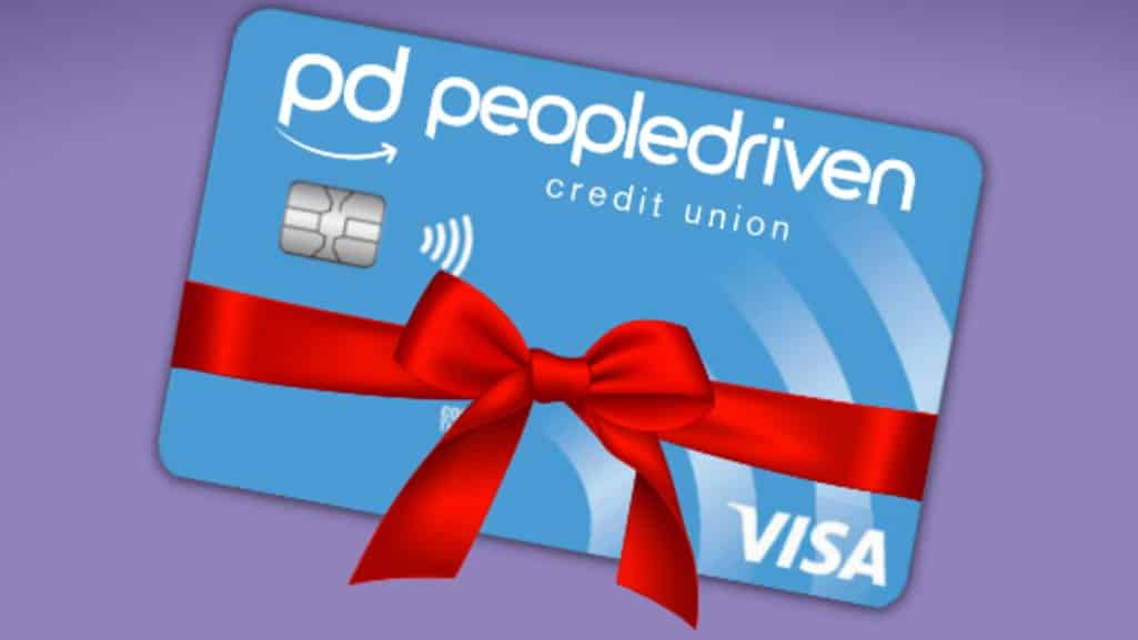 People Driven Credit Union Visa credit card with a red ribbon bow on a purple background, symbolizing the Stretch Your Holiday Dollars promotion.
