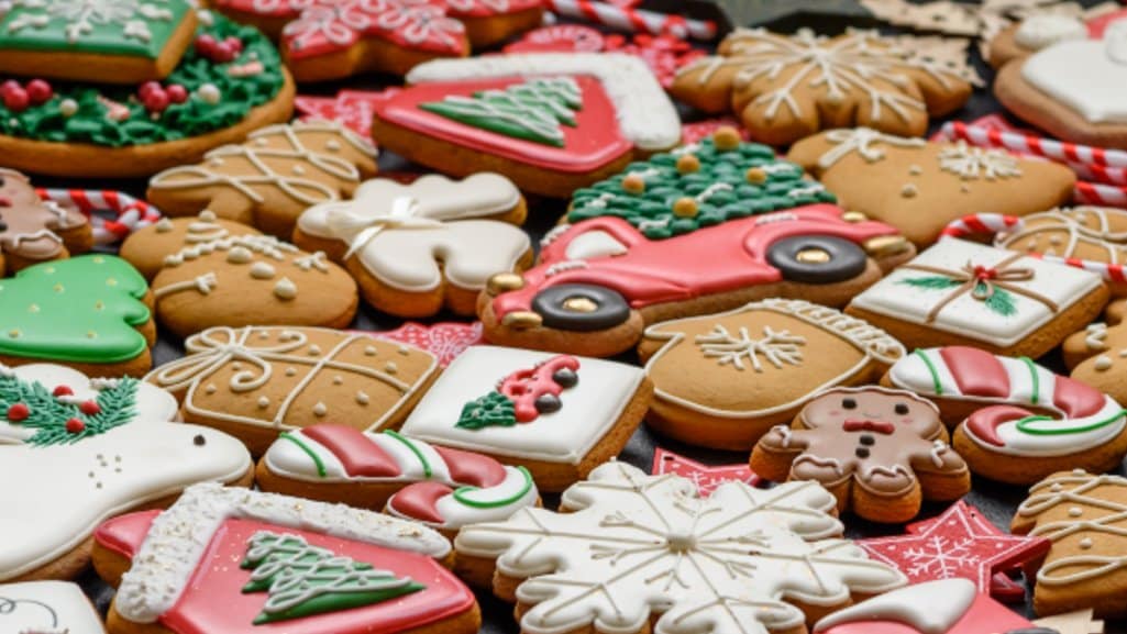 Assorted decorated holiday cookies shaped like trees, snowflakes, presents, and candy canes.