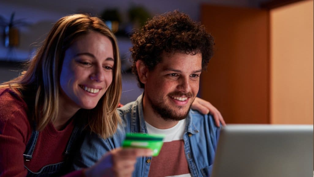 Couple using overdraft tips to avoid fees to make a purchase online.