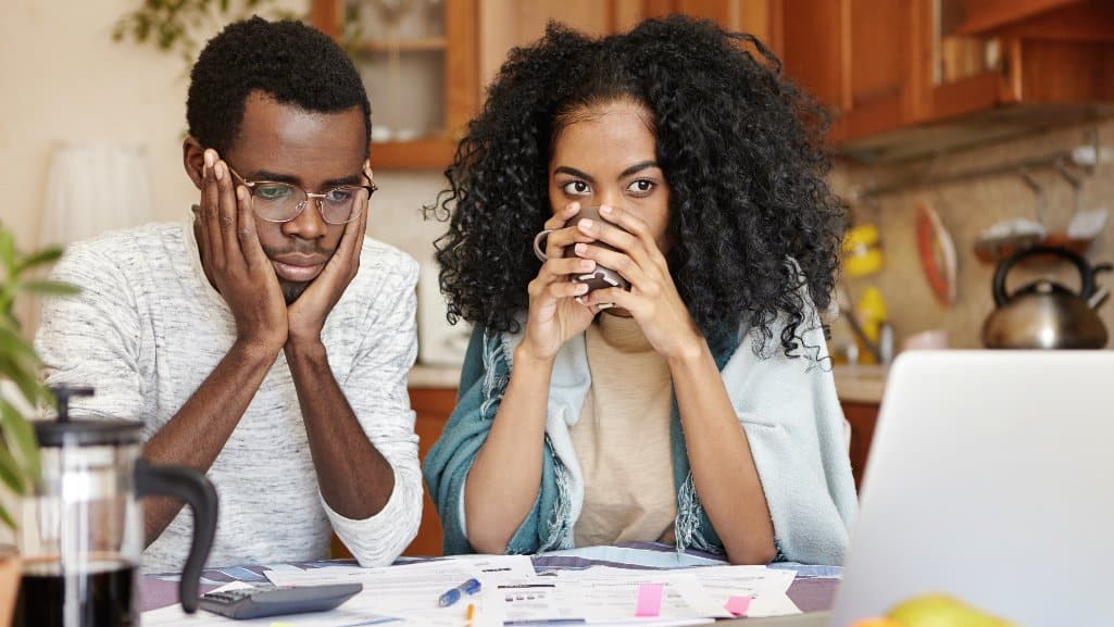 Couple discussing a financial challenge over coffee at the breakfast table.